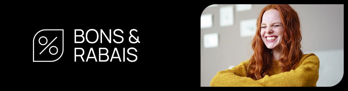 Gutscheine & Rabatte – Person mit rotem Haar und gelbem Pullover steht mit verschränkten Armen vor hellem Hintergrund