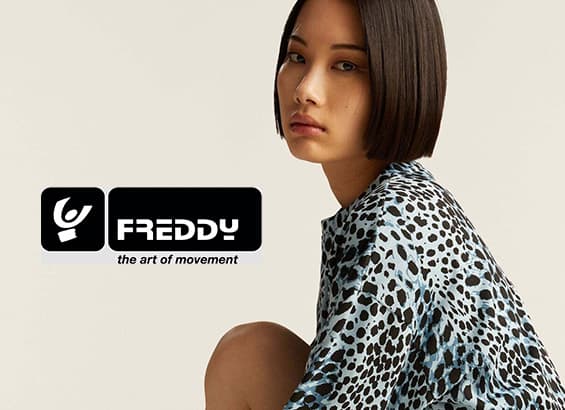 Freddy the art of movement – Frau in gemustertem Oberteil mit Bob-Haarschnitt, Gesicht unscharf.