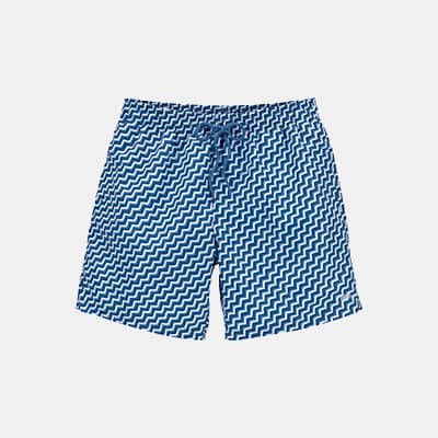Blaue Badeshorts mit weißem Zickzackmuster und Kordelzug, frontal vor hellem Hintergrund liegend