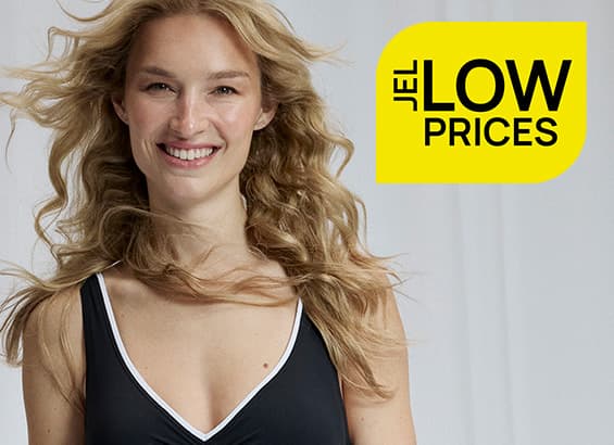 Jellow low prices – lächelnde Frau in schwarzem Top mit weißem Ausschnitt vor hellem Hintergrund
